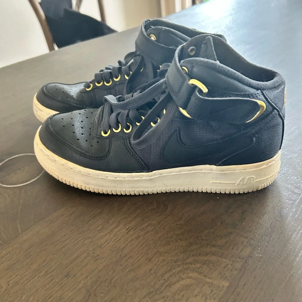 Nike Air Force ones black high top sneakers gold trim